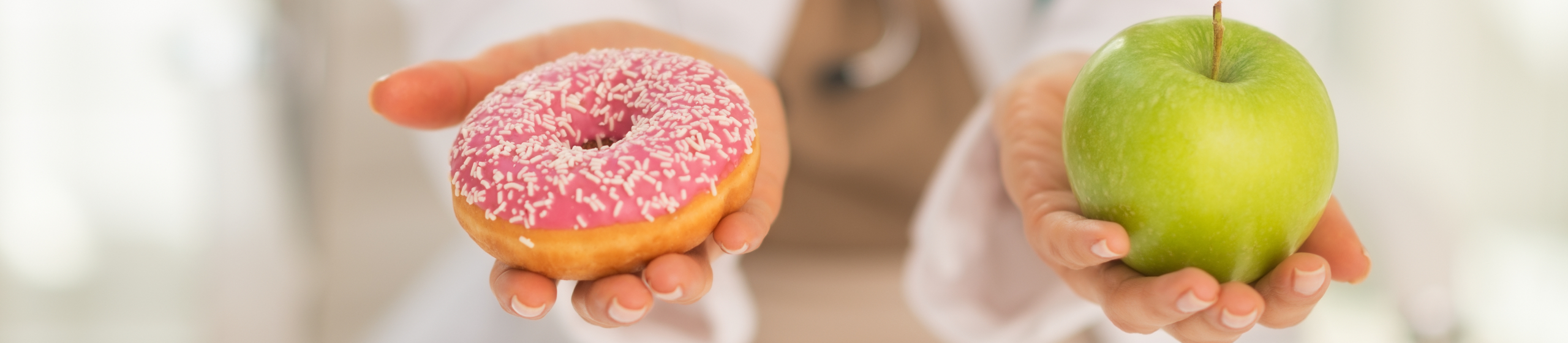 Closeup on medical doctor woman giving a choice between apple and donut